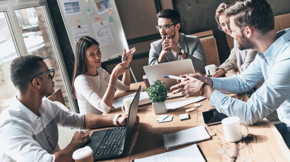 Team at work. Top view of young modern people in smart casual wear discussing business while working in the creative office